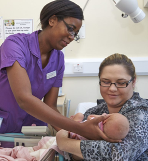 Midwife giving baby to mother